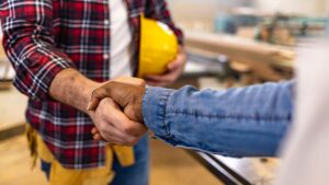 contractor for underground pipe replacement shaking hands with client