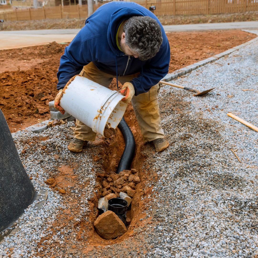 a man fixing underground pipes